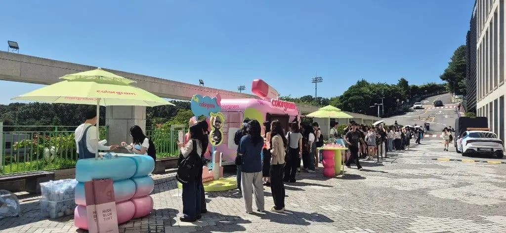 야외 광장의 뷰티 브랜드 팝업 부스와 대기열